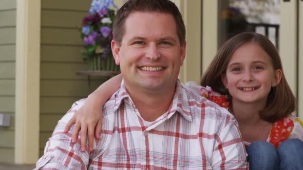 Portrait of father and daughter on porch