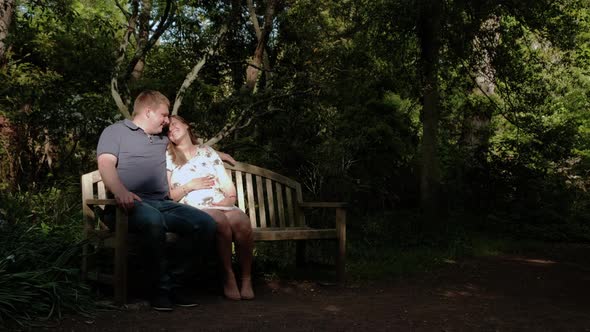 Happy Pregnant Woman and Her Husband in the Forest