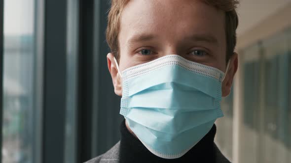 Close up head portrait young serious cautious man employee. Self care worker wearing protective medi