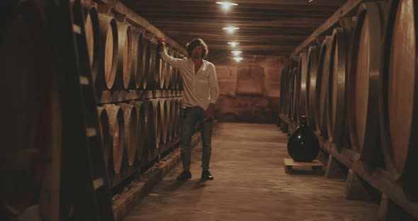 Man stands against wine barrel and looks at the camera