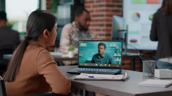 Asian Woman Attending Online Videocall Meeting on Laptop