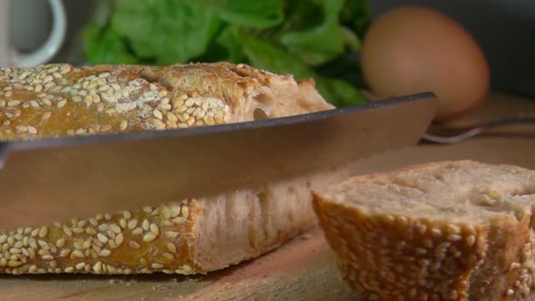 Knife Cutting Baguette with Sesame Seeds