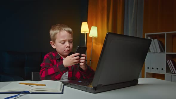 Cute Kid Boy Holding Smart Phone Enjoying Using Mobile Apps Playing Games at Home