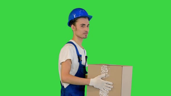 Man Worker Holding a Box and Walking on a Green Screen Chroma Key