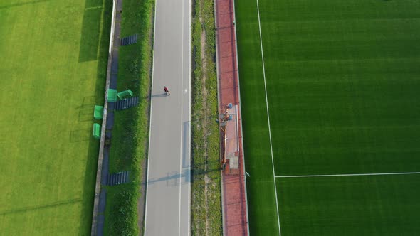 Active Man in Line Skating on the Track Near the Stadium