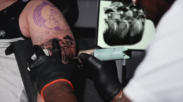 Cinematic Slow Motion Shot of a Tattoo Artist Creating Body Art at the Tattoo Studio