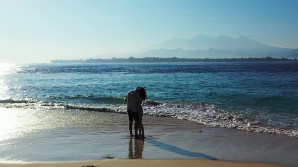 Two people tan on beautiful bay beach wildlife by shallow ocean and white sandy background of Gili A