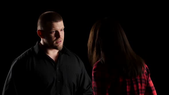 Emotional Man with Woman Says Irritably on Black Background. Close-up