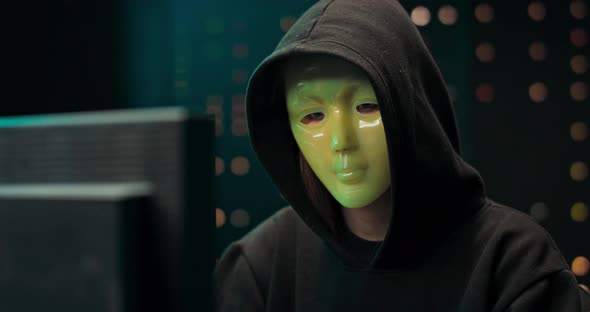 Closeup Shot of Masked Anonymous Hacker Organizes Malware Attack on Global Scale Dangerous