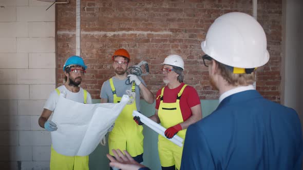 Engineer Discussing Structure of Building with Workers at Construction Site.