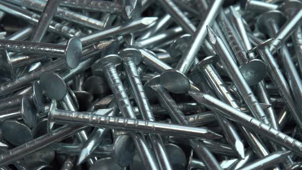 A Pile of Metallic Silver Nails for Construction Work Rotate As a Background Hobnails are Spinning