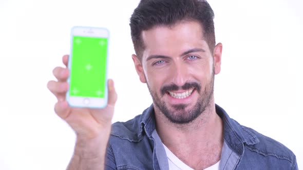 Face of Happy Young Bearded Hipster Man Showing Phone