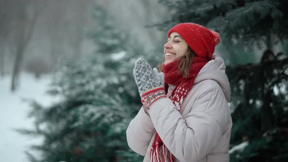 Young Pretty Candid Smiling Happy Woman in Woolen Mittens and Red Hat Wearing Warm Parka Walking