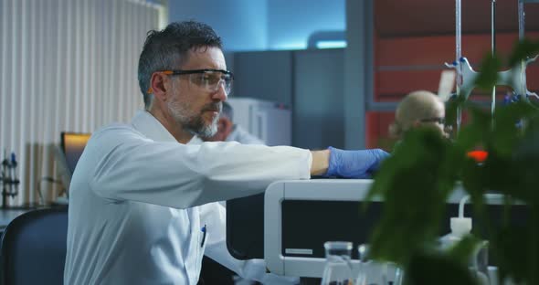 Scientist Loading Vials Into a Testing Machine alt