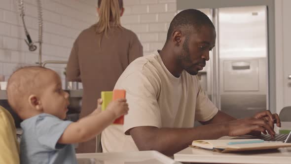 Father Working Next to Baby