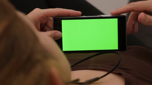 Green screen on phone while listening the music 4K 2160p UHD footage - Woman listening music on snar