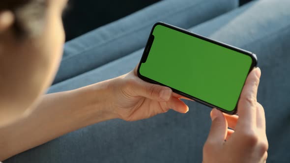 Handheld Camera: Back View of Brunette Woman Holding Chroma Key Green Screen Smartphone