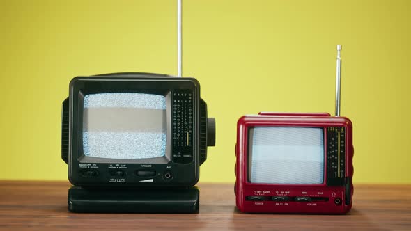 Small Old Televisions with Grey Interference Screen on Yellow Background