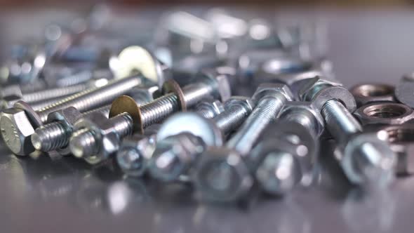 Slider Shot Video of Chrome Bolts and Nuts in a Chaotic Order Industrial Background