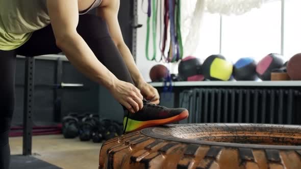 Muscular Sportswoman Tying Shoelaces