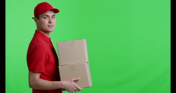 Cheerful Courier in Red Uniform Walking with Parcels