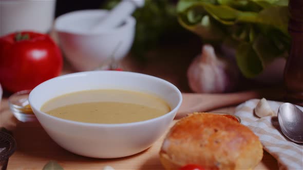 Soup In Bowl Amidst Various Ingredients Assorted On Wooden Table