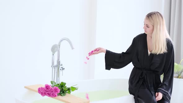 Female Pour Rose Petals Into the Bath