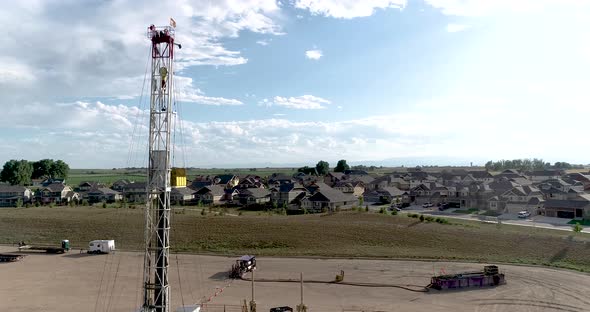 A drilling rig filmed from a drone next to a wealthy neighborhood.