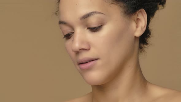 Beauty Portrait of Young African American Woman Cleansing Face with White Cotton Pad Removing Makeup