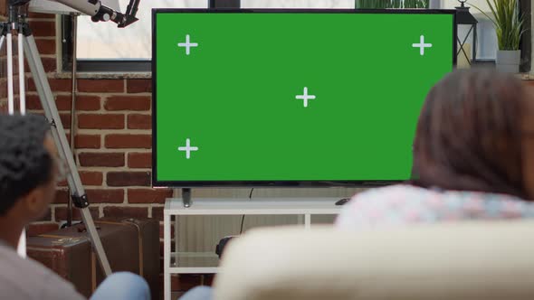 Men and Women Watching Television Display with Green Screen