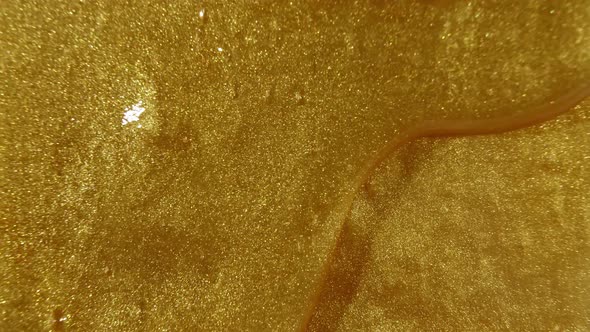 Gold Gel Fluid with Flowing Down on Surface