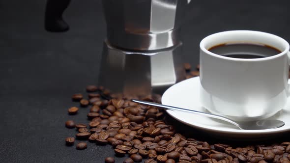 Cup of espresso coffee and mocha coffee maker on roasted brown coffee beans on concrete background