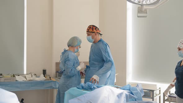 Surgery Medicine and People Concept Nurse Assisting Surgeon and Helping with