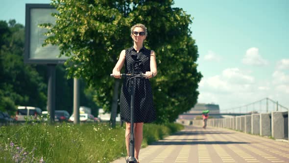 Woman Ride On Electric Scooter Mobility.E-Scooter Rider Rent Personal Eco Transport. Urban Style.