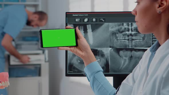 Close Up of Dentist Analyzing Smartphone with Green Screen