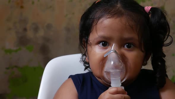 Asian girl about 4 years is being nebulized to cure her respiratory tract.