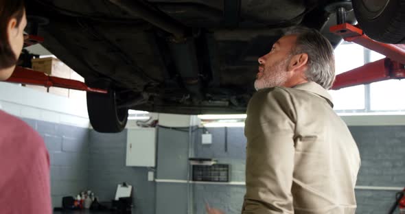 Mechanic showing customer the problem with car