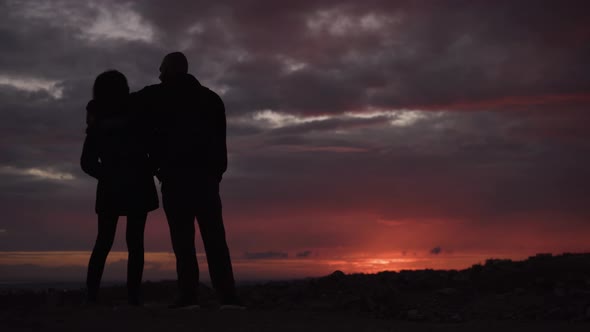 Young Couple Hugging and Looking at Sunset View Together