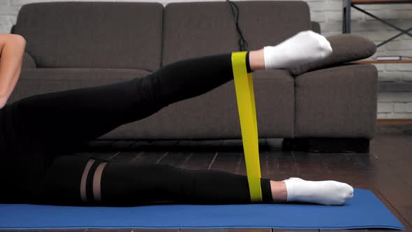 Athletic Woman Sportswoman Doing Legs Exercise with Loop Band on Fitness Mat