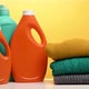 stack of washed folded clothes and plastic orange large bottles with liquid detergent - VideoHive Item for Sale