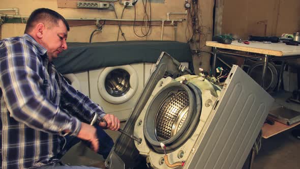 The Technician Bolts the New Part Into the Washing Machine