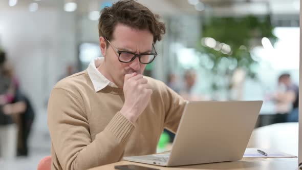 Man with Laptop Coughing in Office