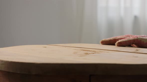 Woman Blowing Dust From Wooden Table After Sanding