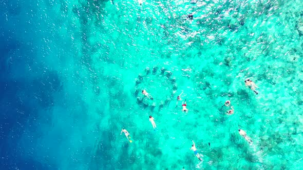 Beautiful above island view of a white sand paradise beach and blue water background in colourful 4K