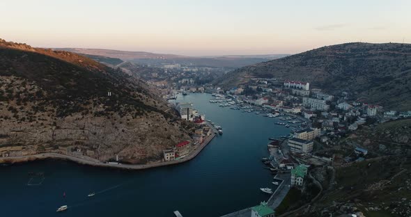 Bay of the Sea, Mountains, Rocks, Embankment and City Buildings