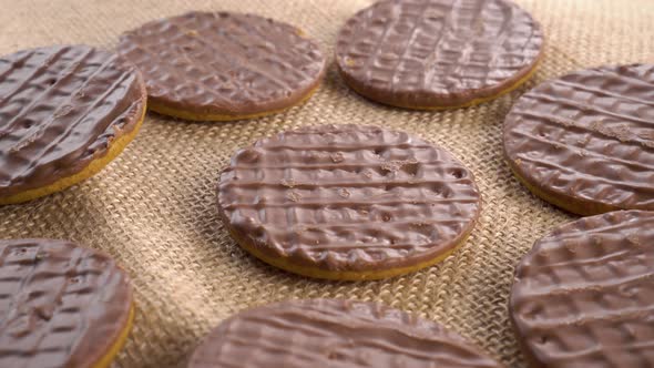 Digestive biscuits coated with dark chocolate on a rough rural sackcloth