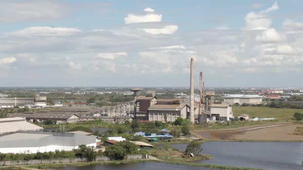 Old Abandoned factory with tall chimneys on vacant land, Aerial orbiting panorama