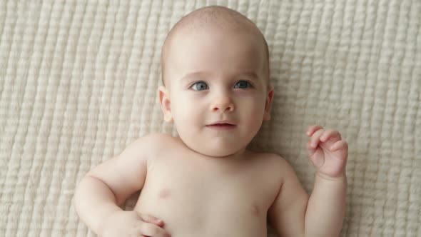 Baby boy lying on blanket, from above