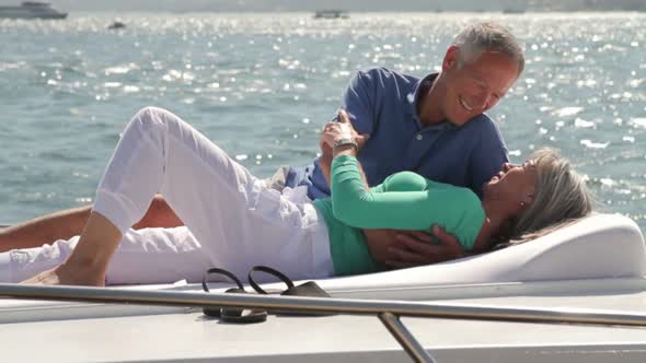 Couple on yacht sunbathing and kissing