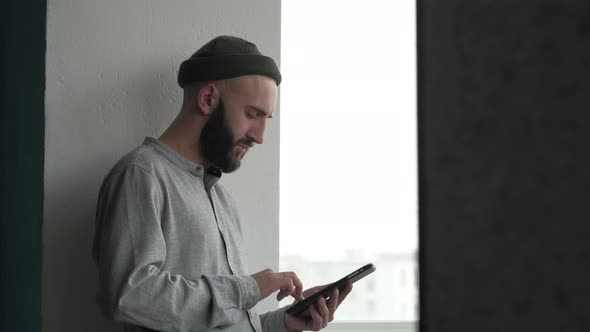 Guy with Beard Buying Online with a Credit Card and a Tablet at Home